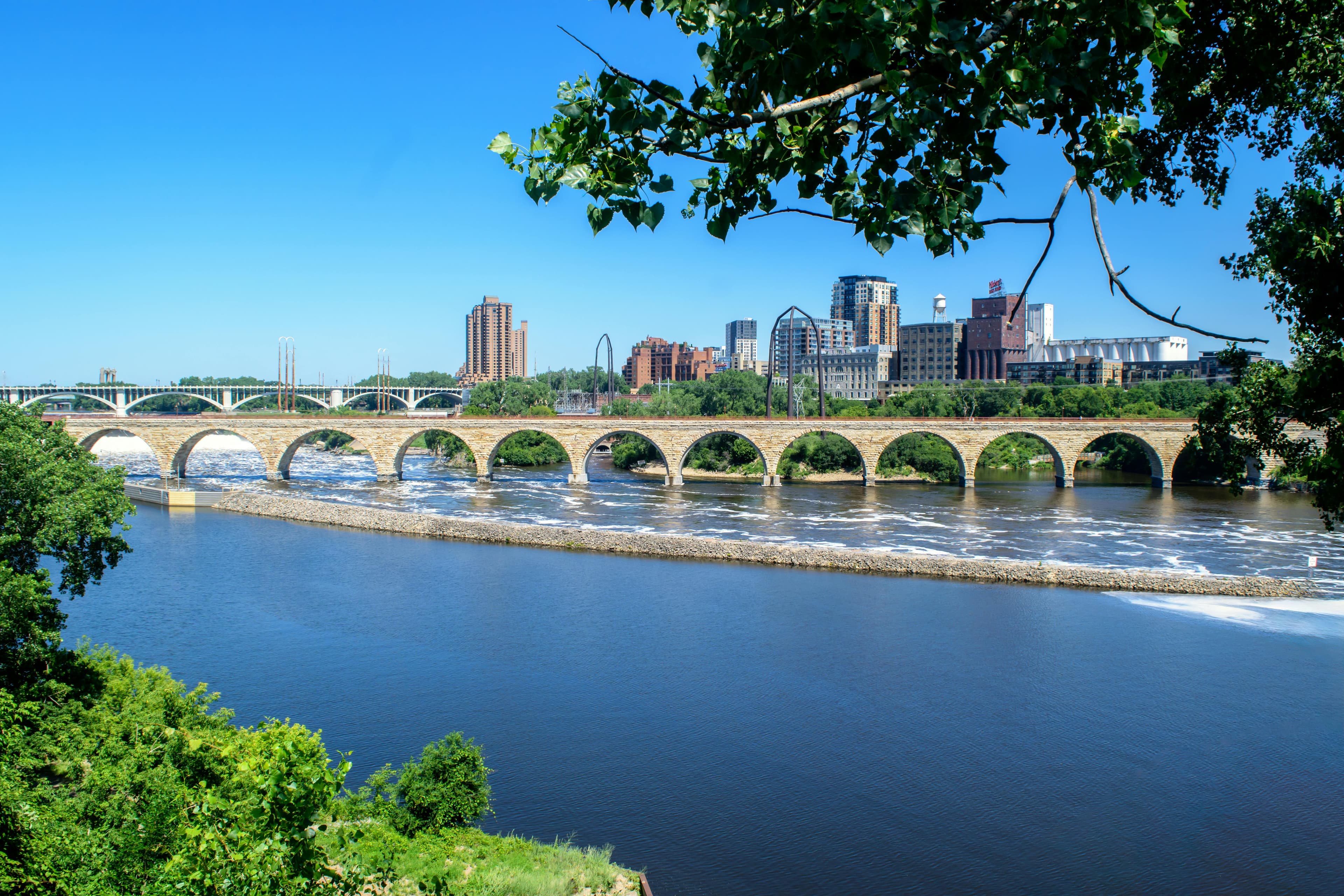 The Stone Arch Bridge spanning the Mississippi River with the Minneapolis skyline in the background